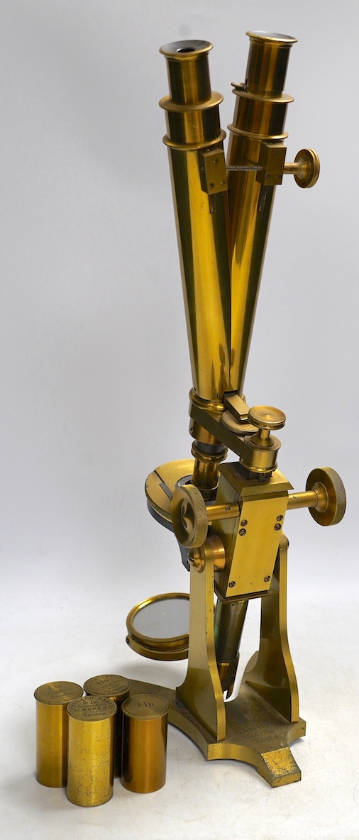 A 19th century brass compound binocular microscope, engraved to the base Baker, 244 High Holborn, London, with four brass cased objective lenses, 47cm high. Condition - fair to good